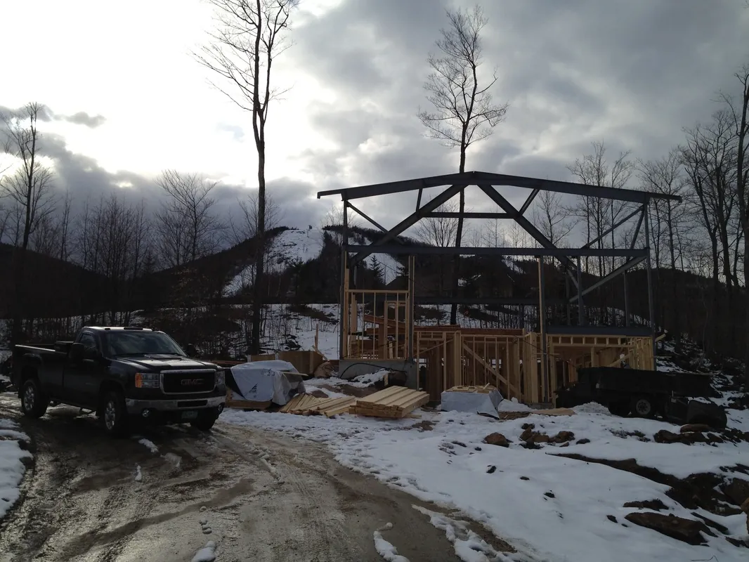 Timber frame rising on a snowy mountain site