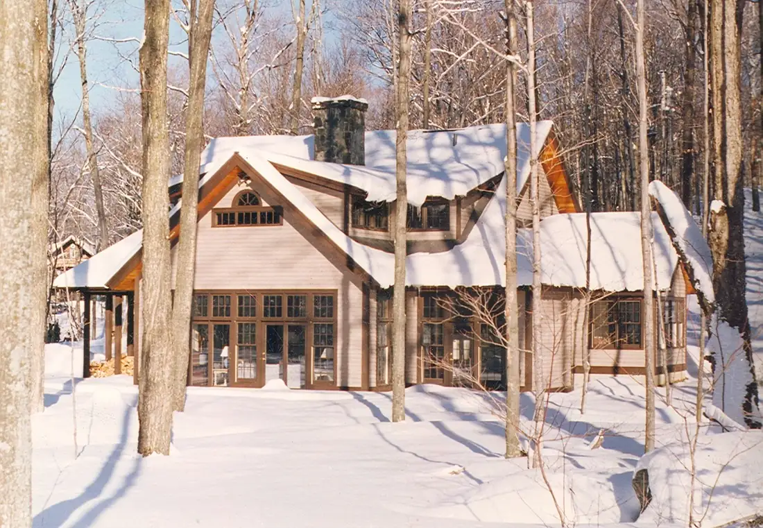 Timber-accented mountain home among birch trees in winter snow