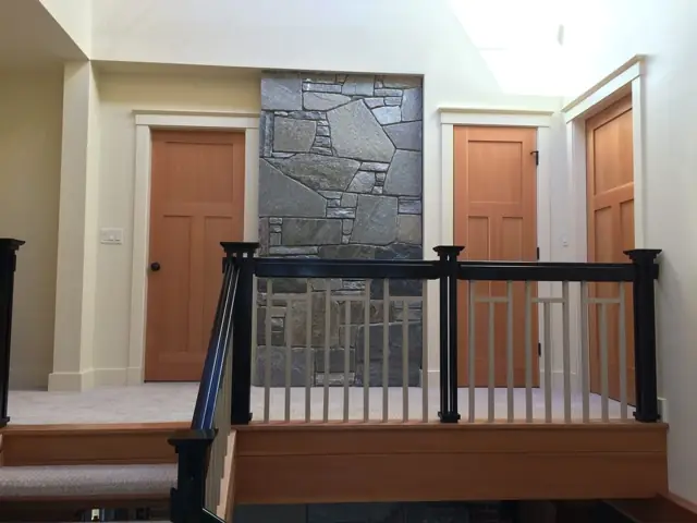 Upper landing with wood doors and a stone accent wall