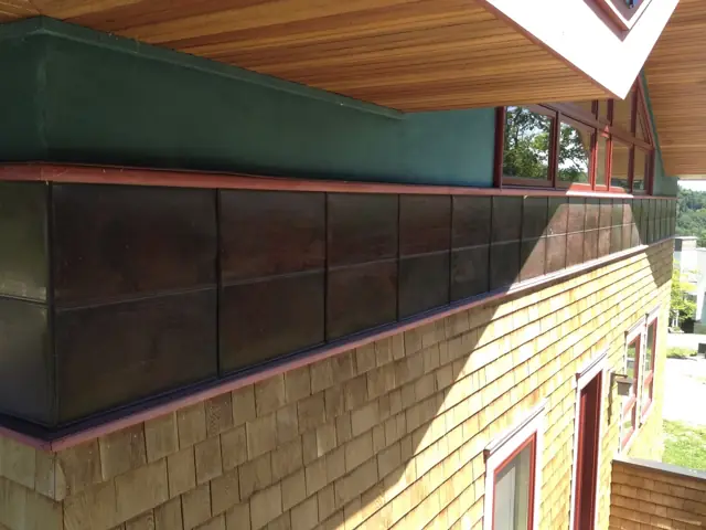 Shingle siding and copper detail under deep eaves
