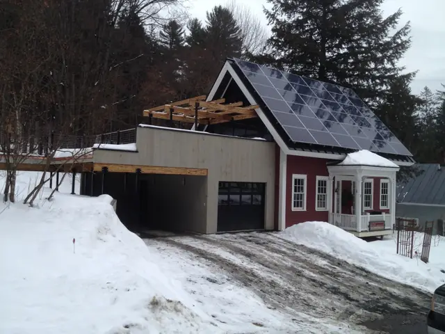 Red-trimmed home and garage in winter
