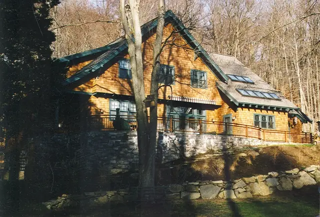 Shingle and timber home framed by evergreen trees