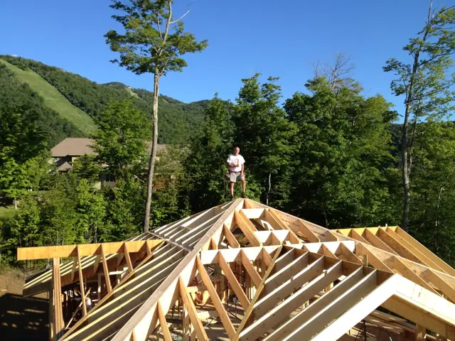Roof framing in progress with mountains in the background
