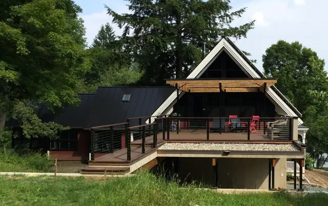 Gabled home with covered deck on a green hillside