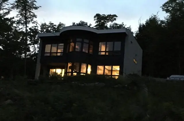 Modern home glowing with interior light at dusk