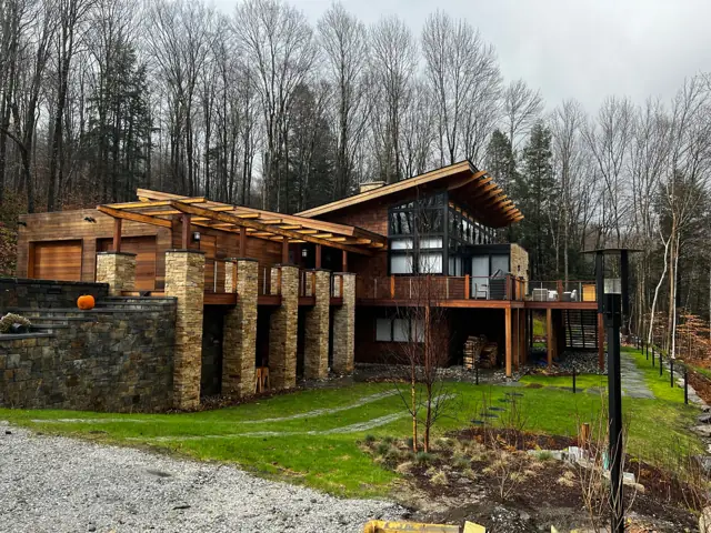 Timber and stone home with pergola-covered terrace